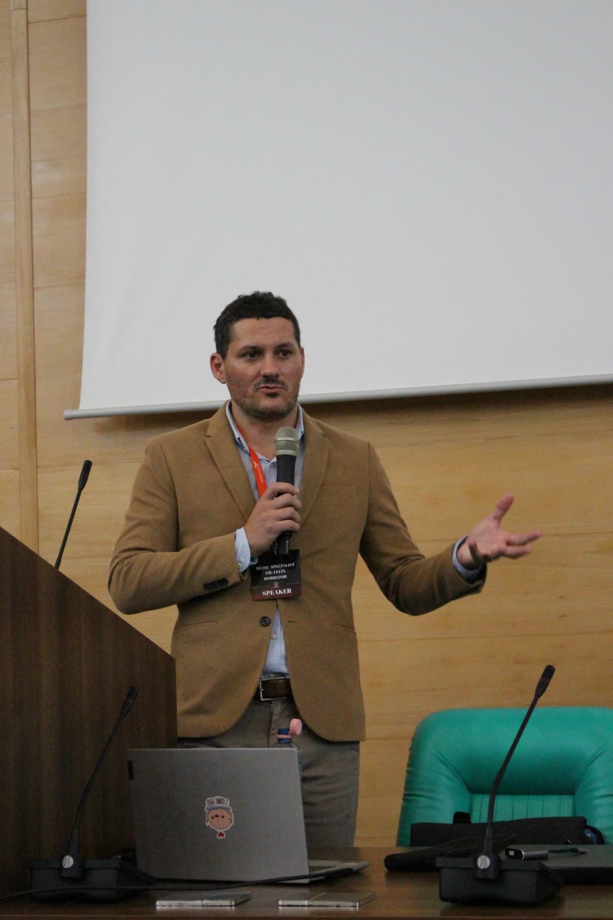 Lector în sacou maro, discutând teme medicale la MIMESISS.