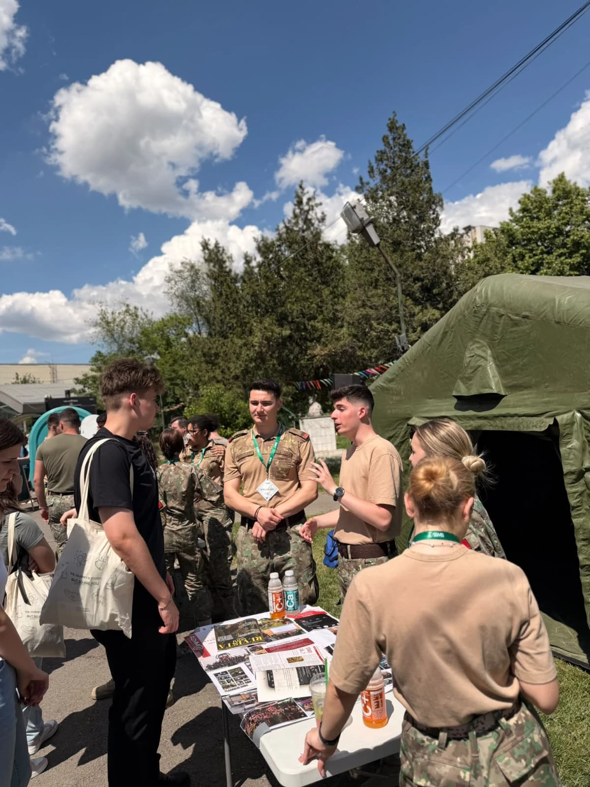 Vizitatori și studenți militari în fața cortului IMM.